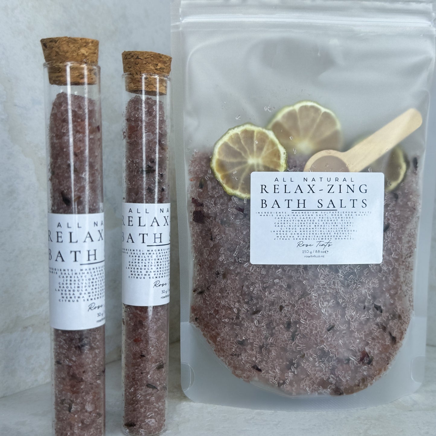 Two test tubes labeled 'RELAX-ZING BATH SALTS' and a clear pouch bag with the same label, indicating a bath salt product with essential oils.