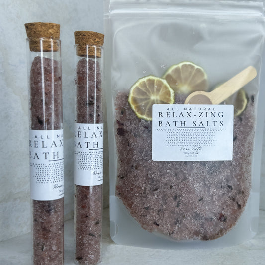 Two test tubes labeled 'RELAX-ZING BATH SALTS' and a clear pouch bag with the same label, indicating a bath salt product with essential oils.