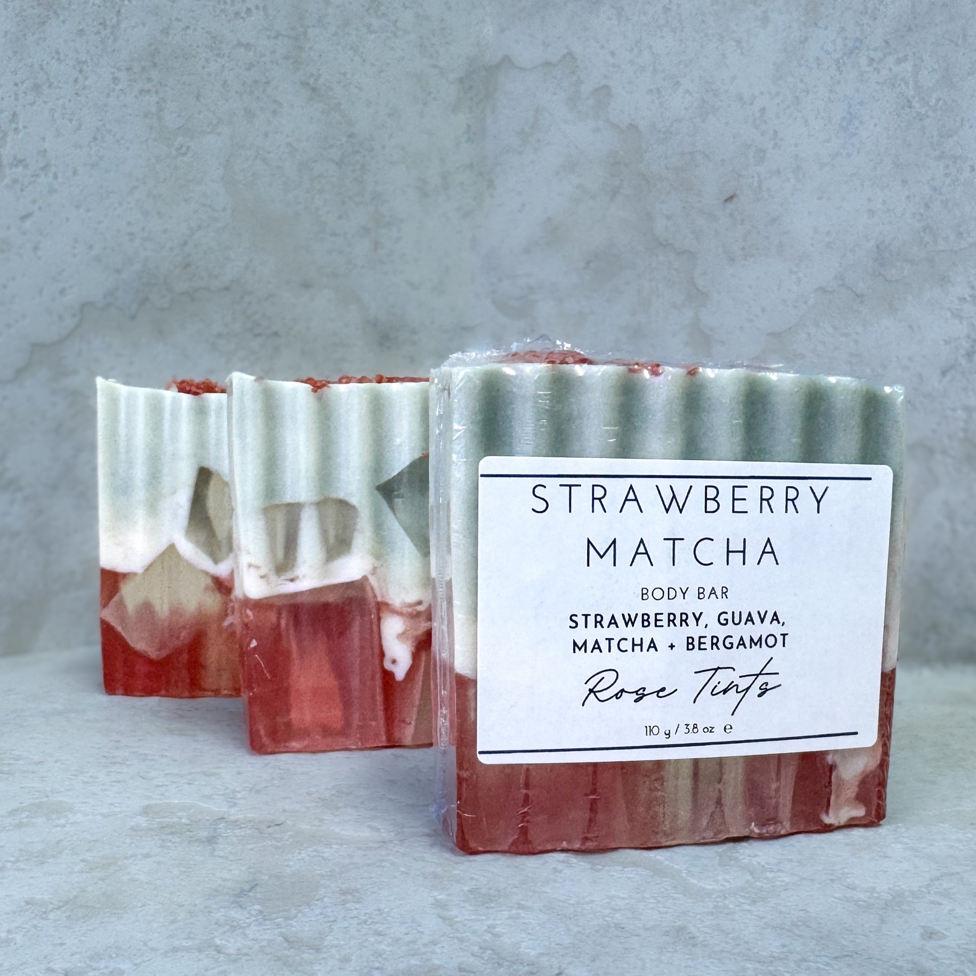 Strawberry Matcha body bar with a label on a gray background